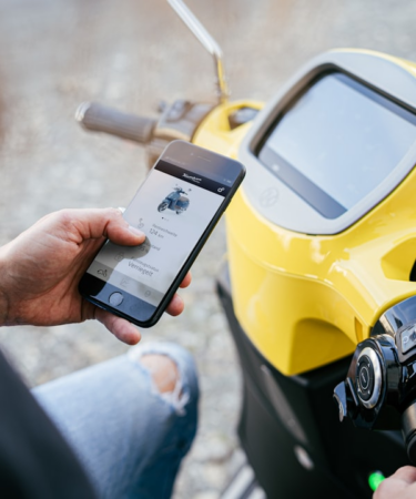 person holding yellow and black digital device — Foto por Kumpan Electric na Unsplash