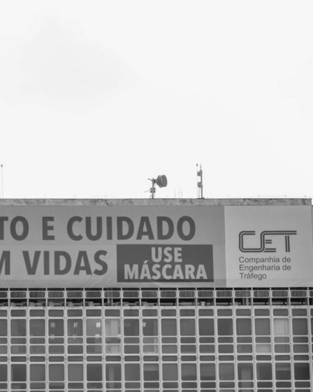 a tall building with a sign on the side of it — Foto por Anderson Menezes Da Silva na Unsplash
