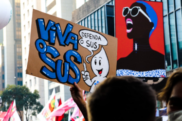 a group of people holding up signs in the air — Foto por Tutz Dias na Unsplash