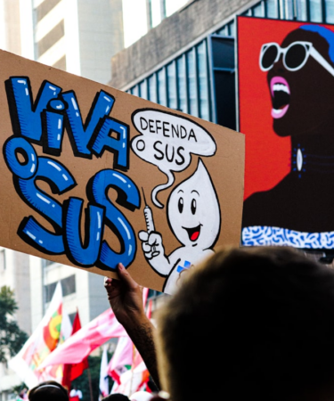 a group of people holding up signs in the air — Foto por Tutz Dias na Unsplash