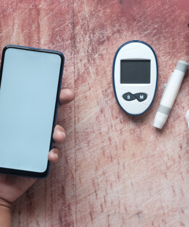 a person holding a smart phone next to an electronic device — Foto por Towfiqu barbhuiya na Unsplash