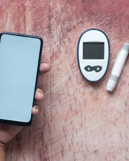 a person holding a smart phone next to an electronic device — Foto por Towfiqu barbhuiya na Unsplash