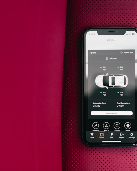 Smartphone displaying car control app on red seat — Foto por Erik Mclean na Unsplash