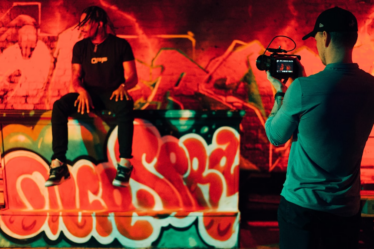 man in black and white crew neck t-shirt holding black dslr camera — Foto por Gordon Cowie na Unsplash