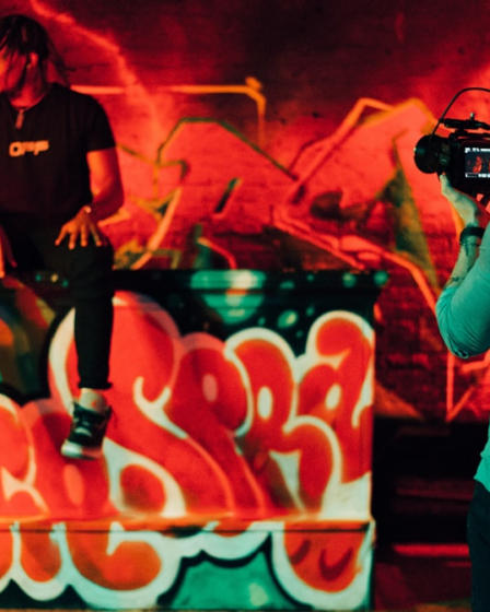 man in black and white crew neck t-shirt holding black dslr camera — Foto por Gordon Cowie na Unsplash