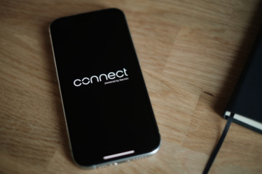 A cell phone sitting on top of a wooden table — Foto por appshunter.io na Unsplash