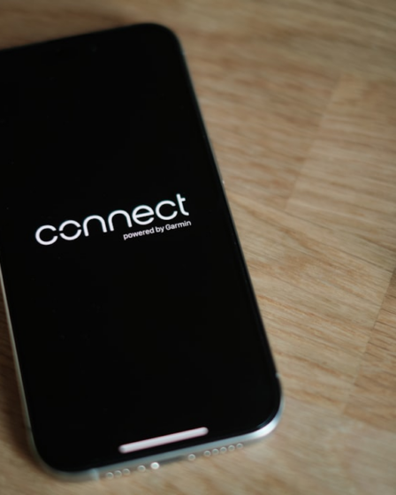 A cell phone sitting on top of a wooden table — Foto por appshunter.io na Unsplash