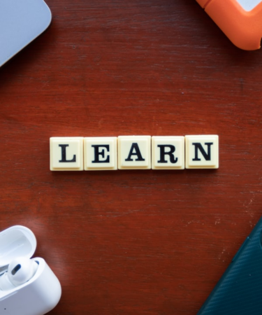 the word learn spelled with scrabble letters on a wooden table — Foto por Ling App na Unsplash