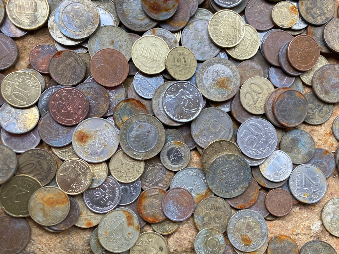 a pile of different types of coins — Foto por Elena Mozhvilo na Unsplash