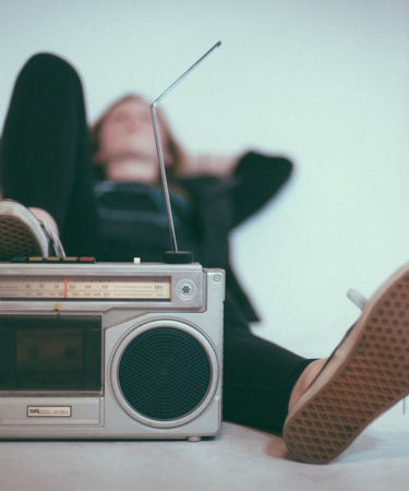 woman laying on bed near gray radio — Foto por Eric Nopanen na Unsplash