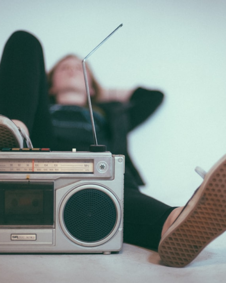 woman laying on bed near gray radio — Foto por Eric Nopanen na Unsplash