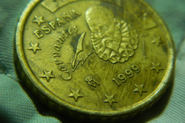 A close up of a gold coin with stars on it — Foto por ashinJPG na Unsplash