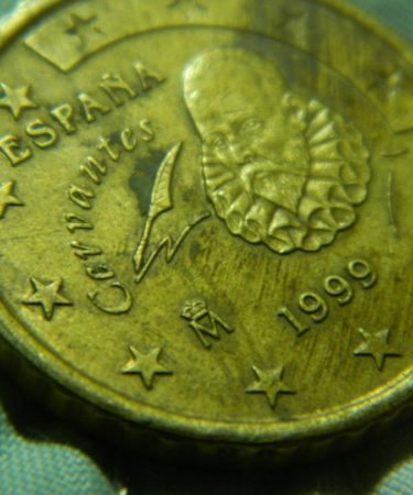 A close up of a gold coin with stars on it — Foto por ashinJPG na Unsplash