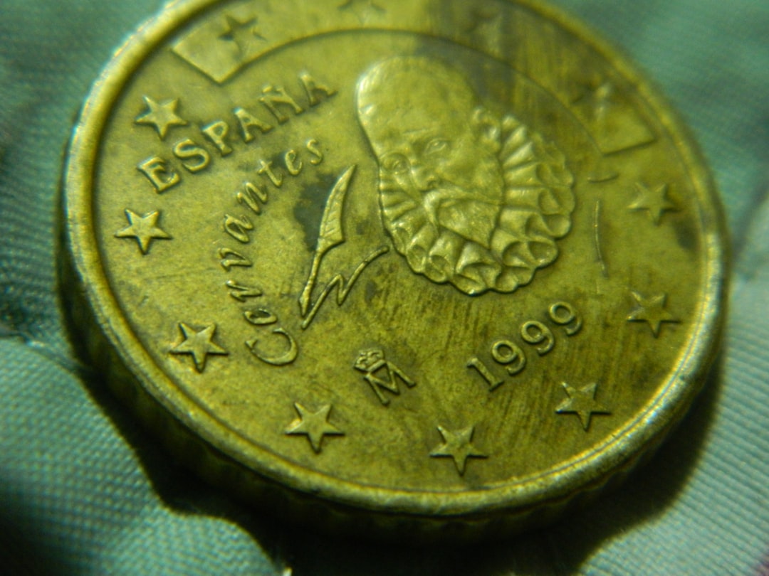 A close up of a gold coin with stars on it — Foto por ashinJPG na Unsplash
