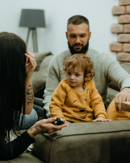 a man sitting on a couch next to a little girl — Foto por Tamara Govedarovic na Unsplash