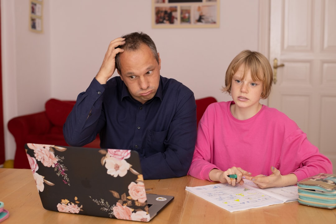 man in blue dress shirt sitting beside girl in pink long sleeve shirt — Foto por sofatutor na Unsplash
