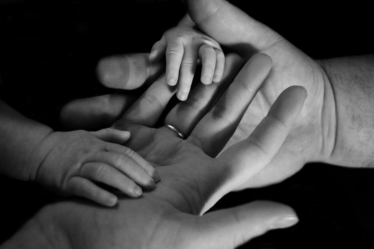 babys hand on human palm — Foto por Liv Bruce na Unsplash