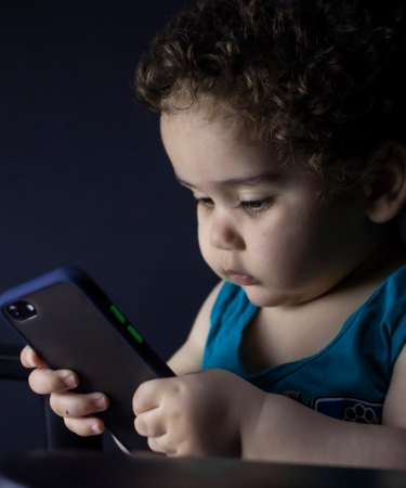 boy in blue tank top holding black iphone 5 — Foto por hessam nabavi na Unsplash