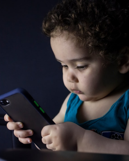 boy in blue tank top holding black iphone 5 — Foto por hessam nabavi na Unsplash