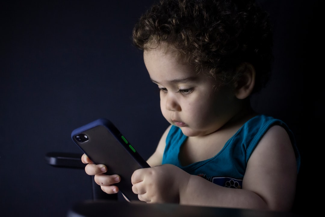boy in blue tank top holding black iphone 5 — Foto por hessam nabavi na Unsplash