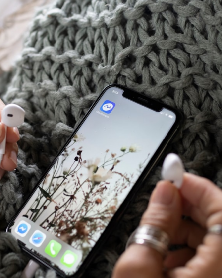 a person holding a cell phone and ear buds — Foto por Mindfulness Com na Unsplash