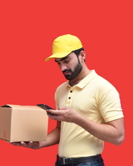 a man in a yellow hat looking at a phone — Foto por Fotos na Unsplash