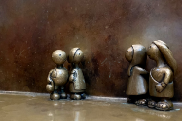 three metal figurines of people standing next to each other — Foto por Praveen Kumar Nandagiri na Unsplash