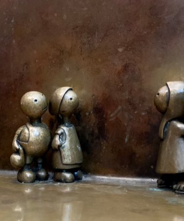 three metal figurines of people standing next to each other — Foto por Praveen Kumar Nandagiri na Unsplash