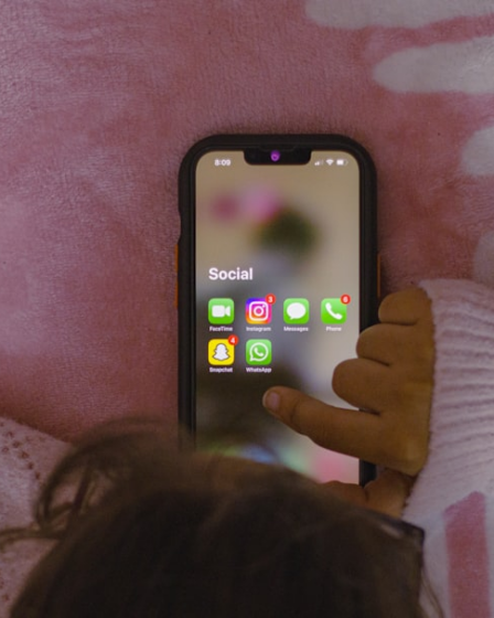 a person laying in bed holding a cell phone — Foto por Sanket Mishra na Unsplash
