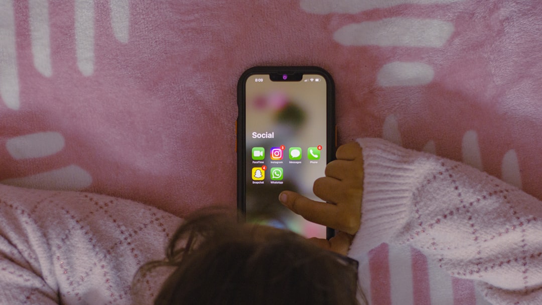 a person laying in bed holding a cell phone — Foto por Sanket Mishra na Unsplash