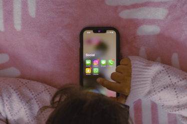 a person laying in bed holding a cell phone — Foto por Sanket Mishra na Unsplash