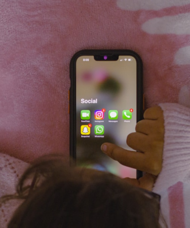 a person laying in bed holding a cell phone — Foto por Sanket Mishra na Unsplash
