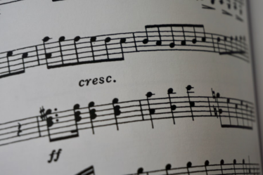 a close up of a book with musical notes — Foto por Karen Chew na Unsplash