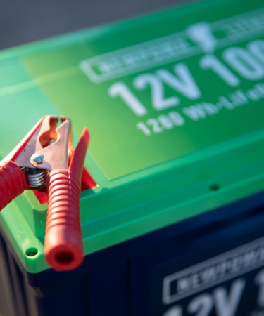a red and green battery with a pair of pliers attached to it — Foto por Newpowa na Unsplash