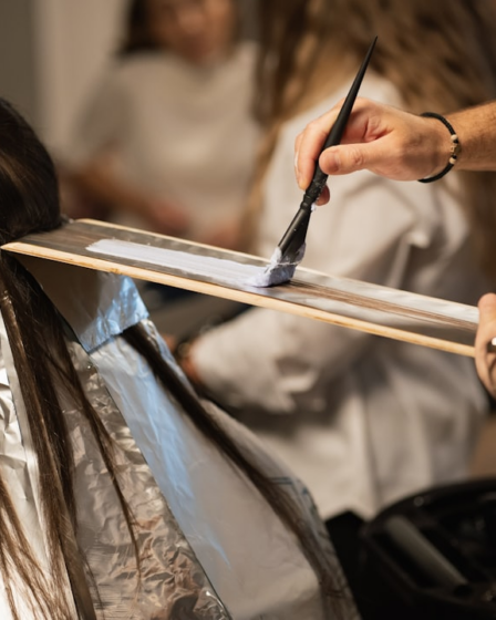 a man cutting a woman's hair with a pair of scissors — Foto por Ionela Mat na Unsplash