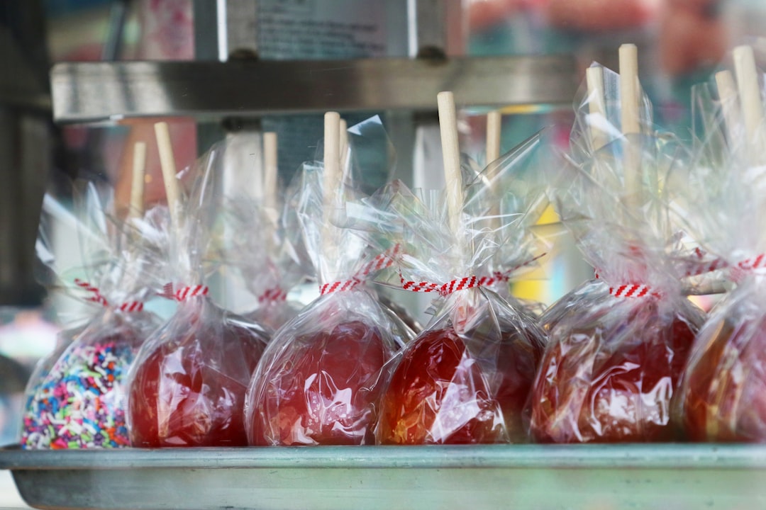 Candy apples on sticks, sticks wrapped in plastic — Foto por David Trinks na Unsplash