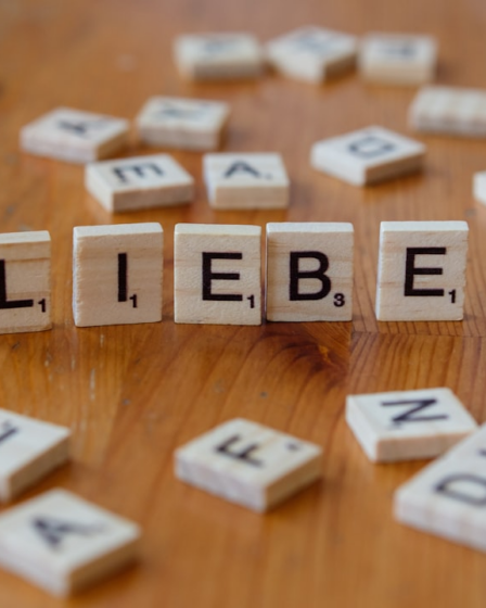 A wooden table topped with blocks that spell out the word liebe — Foto por Markus Winkler na Unsplash
