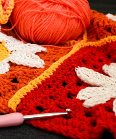 Crocheted squares with yarn and hook — Foto por Nicole Almendrada na Unsplash