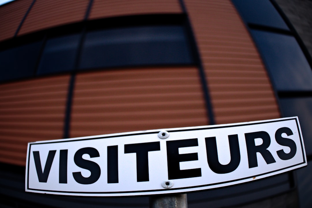 a white street sign sitting in front of a building — Foto por Danielle-Claude Bélanger na Unsplash