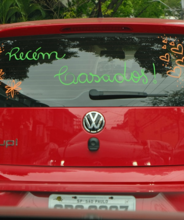 A red car celebrates newlyweds with signage. — Foto por Camila Mofsovich na Unsplash