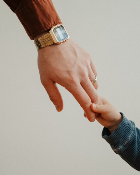 a person holding the hand of a child — Foto por Andrik Langfield na Unsplash