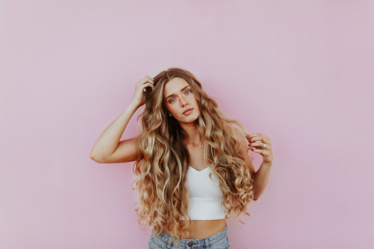 woman standing next to pink wall while scratching her head — Foto por averie woodard na Unsplash